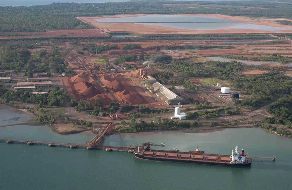 Aerial view of a coastal industrial port and red earth landscape